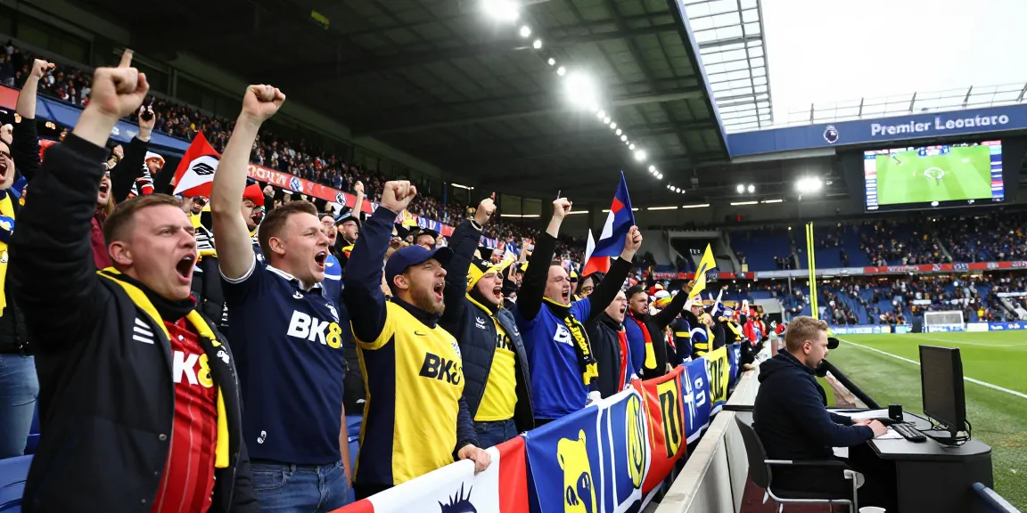 Excited football fans wearing BK8 gear celebrating a Premier League match in a packed stadium.
